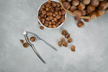 Hazelnuts with nutcracker on gray background. Top view of nuts.
