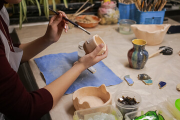 A human sculptor makes a clay product with his own hands
