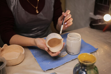 A human sculptor makes a clay product with his own hands