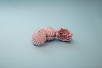 Sweet marshmallow lies on a blue background, minimalism, dessert