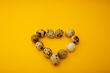 Small quail eggs lie on a yellow background, minimalism for advertising