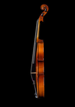 Violin side view isolated on black background.