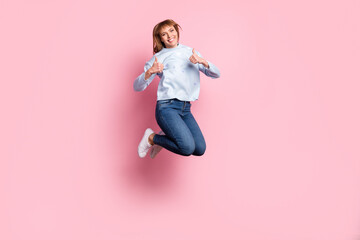 Full length body size view of attractive cheerful girl jumping showing two double thumbup isolated over pink pastel color background