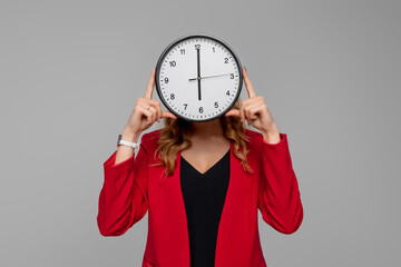 Young woman Holding Big Clock Covering her Face, she wonders how much time passed, standing in red...