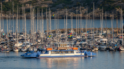 Marstrand, Sweden - July 2021: Marstrand island Harbour and public Ferry transportation in the canal against the blue sky in west coast of Sweden.