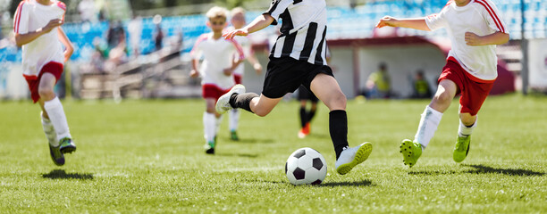 Obraz na płótnie Canvas School Soccer Players Running After Ball and Kicking League Match. Group of Kids Footballers in a Duel. Soccer Players in Sporty Jersey T-shirts and Turf Cleats