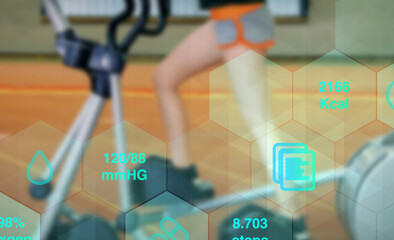 digital tracking of health data and fitness with legs of a woman while workout on a fitness stepper...