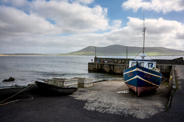 The pier on Rinroe point, Ireland. A fisherman is fishing with his rod.