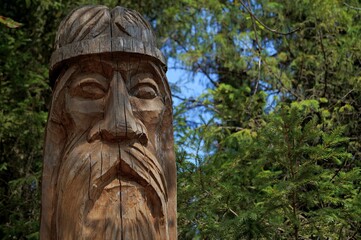 Fototapeta na wymiar Slavic pagan idol in the forest. A wooden statue, an image of a Slavic god. An attribute of religious rites.