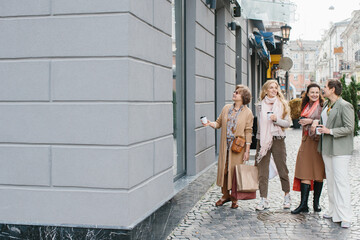 Fototapeta na wymiar Older women, best friends have fun walking the streets of the city shopping.