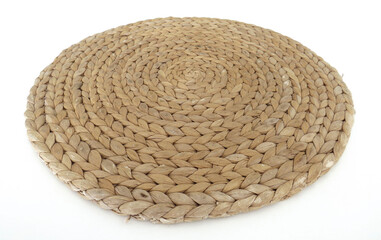 Fototapeta na wymiar View of handmade round beige wicker tablecloth surface isolated on white background; Close-up of single oval water mat of water hyacinth fabric. Rustic decoration. Environmentally friendly. Household.