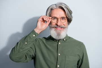 Portrait of attractive cheerful experienced grey-haired man touching specs health care isolated over gray pastel color background