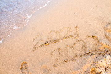 Countdown New Year 2021-2022 numbers are written on sand on sea beach. New Year 2021 is coming...