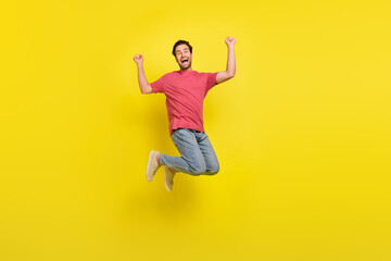Fototapeta na wymiar Full body photo of cool brunet millennial guy jump yell wear t-shirt jeans shoes isolated on yellow background
