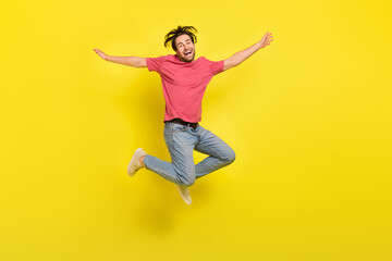 Full size photo of hooray brunet young guy jump wear t-shirt jeans footwear isolated on yellow background