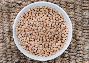 Bowl of Raw uncooked chickpeas on rustic surface
