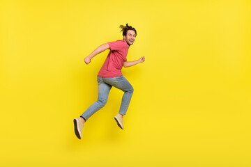 Fototapeta na wymiar Full size profile photo of brunet young guy run wear red t-shirt jeans sneakers isolated on yellow background
