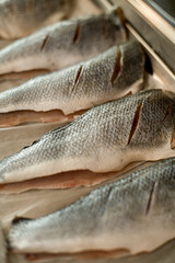 close-up of peeled and gutted fish with incisions on a baking sheet