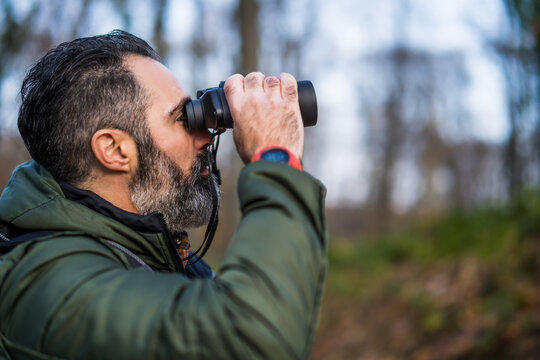 Image of man hiking and using binoculars.	
