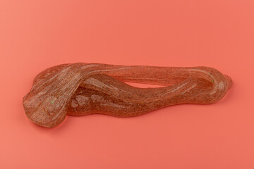 Coral transparent slime with bubbles inside on pink background. Kids toy slime.
