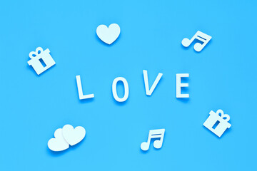 word LOVE, gifts, hearts and music notes on a blue background
