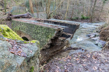 Fototapeta na wymiar Flooding river creek destroyed a bridge after heavy rain flood water shows the forces of nature and the need for insurance against dangerous weather, windstorms, cyclones, tornados and hurricanes