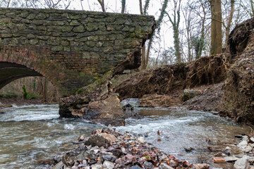 Flooding river creek destroyed a bridge after heavy rain flood water shows the forces of nature and...