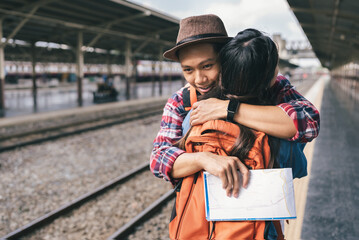 Traveler embracing girl friend at train station