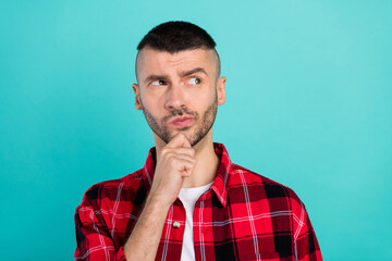 Photo of minded young cool man hold hand chin look empty space think idea isolated on teal color...
