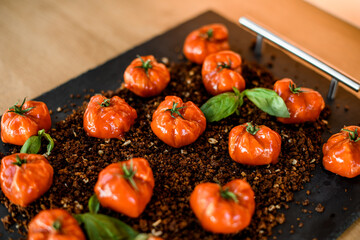 selective focus of tasty baked red cherry tomatoes decorated with green leaves.