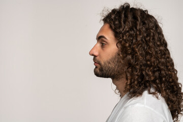 Side view of young curly Hispanic man's head, isolated on white background.