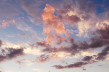 Orange and dark clouds against blue sky at sunset