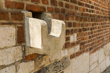 A stone drainage trough protruding from the wall.