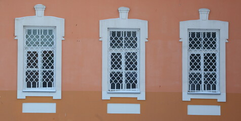 Three white barred windows in the wall