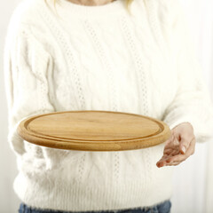 Person holding a wooden tray. Free space for your decoration. 