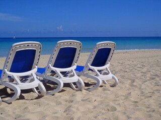 Sun loungers on a sandy deserted beach.