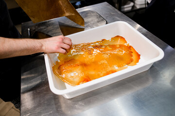 Beautiful transparent sweet golden congealed caramel sugar crust in white tray
