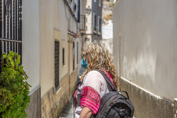 Fototapeta na wymiar Tourist woman walks down a street in a town in Spain