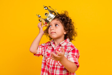 Photo of adorable doubtful schoolgirl wear plaid outfit gold crown looking empty space isolated yellow color background