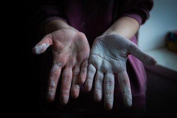 beautiful women's hands smeared in white paint after working with their hands . home renovation. painting works. hands covered in paint. whitewashing the texture