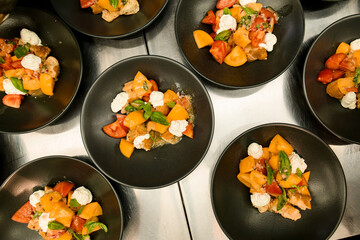 top view on plates with tasty salad of basil mozzarella tomatoes and pieces of baguette