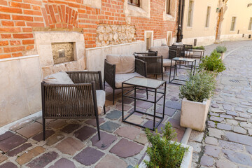 Empty tables and chairs in front of the restaurant, ready to receive customers.