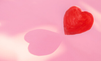 shadow form heart shape on pink paper .Love, and Valentine's Day