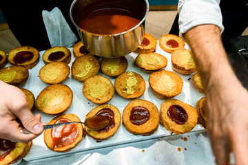 view of hamburger bun halves which hand of chef anointed with ketchup and mustard