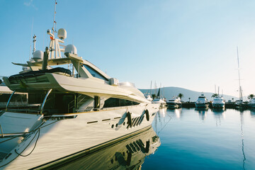Fototapeta premium White motor yacht at the pier in Porto Montenegro
