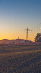 power lines on the field at sunset