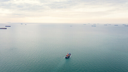 aerial seascape view and small container ship floating in sea horizon and cloud sky background