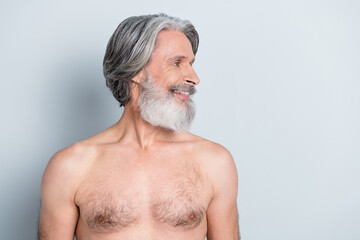 Photo of cheerful positive mature man naked torso looking empty space smiling isolated grey color background
