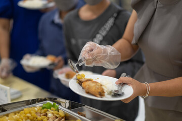 a person wearing gloves scooping food, catering, dinner time, prevent Coronavirus disease (covid 19)