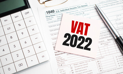 VAT 2022 with pen, calculator, glass and sticker. Tax report sign